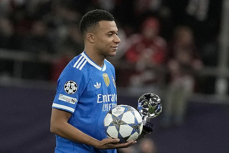 Real Madrid's Kylian Mbappe poses with the trophy after scoring four goal during the Champions League opening phase soccer match between Olympiacos and Real Madrid, in in Piraeus port, near Athens, Greece. - | Photo: AP/Petros Giannakouris