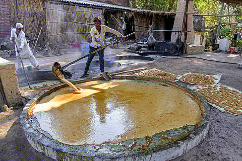 Workers prepare jaggery at a small scale unit, in Dehradun.