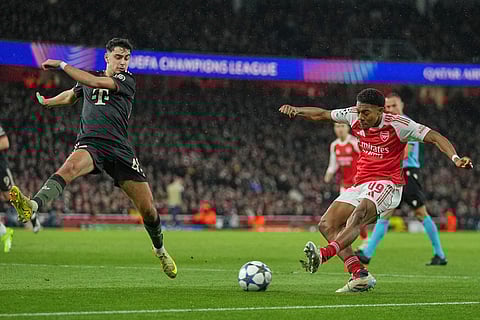 Arsenal's Myles Lewis-Skelly gets in a shot as Bayern's Aleksandar Pavlovic tries to block during the Champions League opening phase soccer match between Arsenal and Bayern Munich in London.