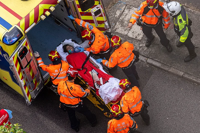 Health workers vacuating woman, hong kong fire.