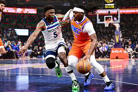 Oklahoma City Thunder guard Luguentz Dort (5) drives against Minnesota Timberwolves guard Anthony Edwards (5) during the first half of an Emirates NBA Cup basketball game in Oklahoma City. 