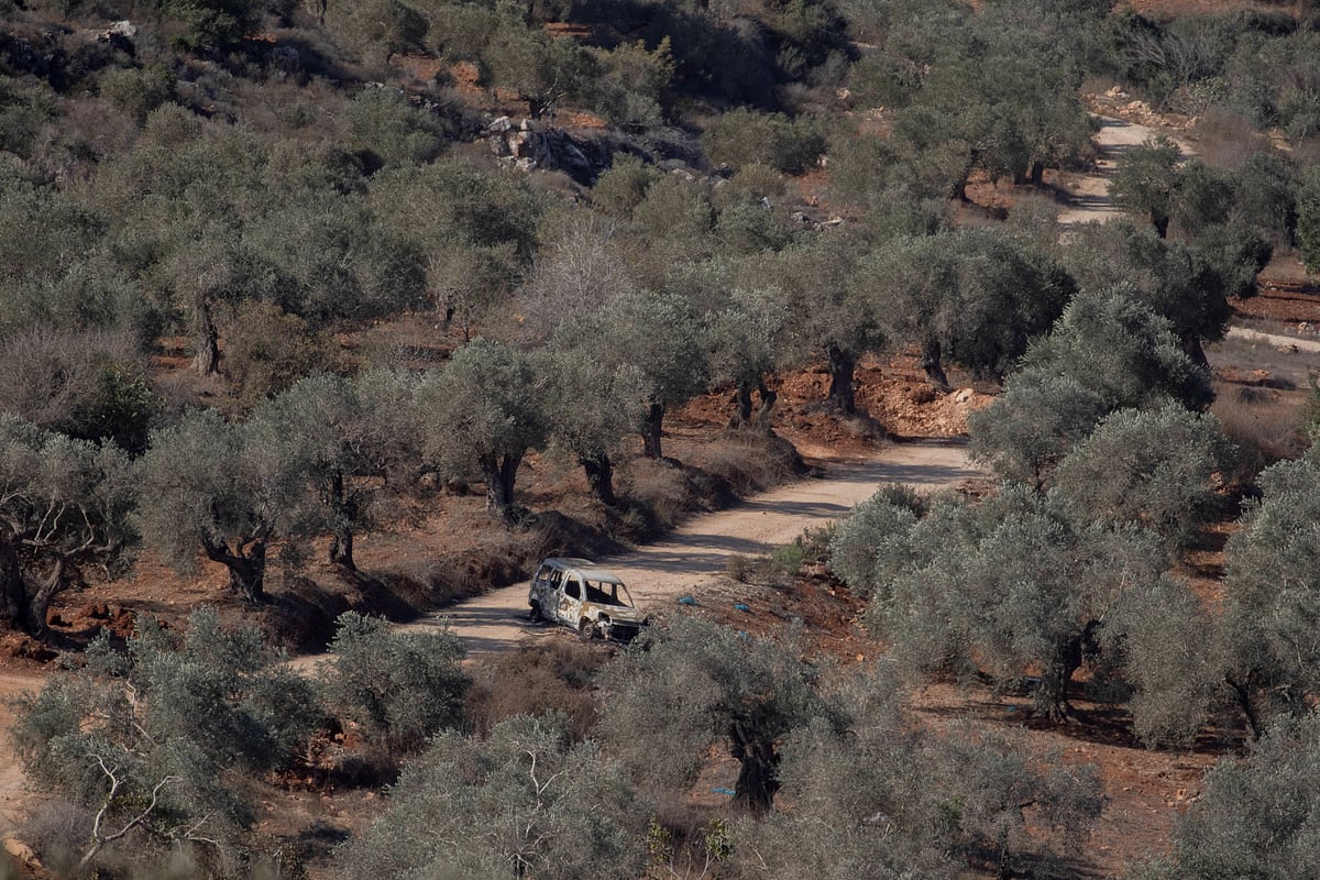 A burned-out vehicle sits on a dirt road among olive trees in the village of Baita, south of Nablus in the occupied West Bank, on November 1, 2025. Tensions have risen in the area as settlers and Israeli forces confront Palestinian farmers during the olive harvest season.  - IMAGO / Middle East Images
