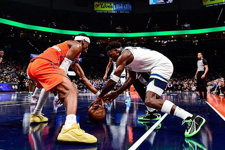 Oklahoma City Thunder guard Shai Gilgeous-Alexander (2) goes for the free ball against Minnesota Timberwolves guard Anthony Edwards (5) during the second half of an Emirates NBA Cup basketball game in Oklahoma City. - | Photo: AP/Gerald Leong