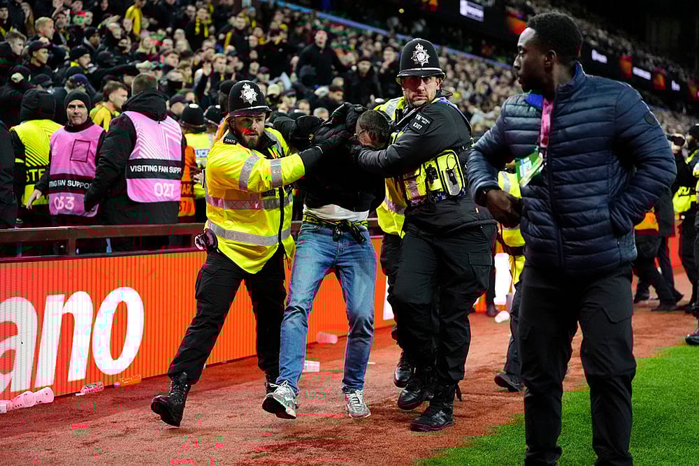 A Young Boys fan is escorted from the stadium by police during the Europa League soccer match between Aston Villa and Young Boys in Birmingham, England. - | Photo: Nick Potts/PA via AP