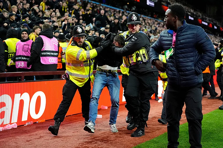 A Young Boys fan is escorted from the stadium by police during the Europa League soccer match between Aston Villa and Young Boys in Birmingham, England. - | Photo: Nick Potts/PA via AP