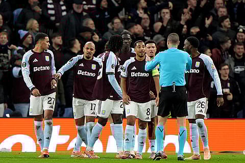 Aston Villa players speak to the referee after scorer Donyell Malen, second left, was hit by an object during the Europa League soccer match between Aston Villa and Young Boys in Birmingham, England.