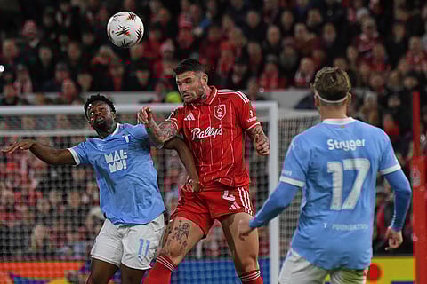 Nottingham Forest's Morato, centre, heads the ball under pressure from Malmo's Emmanuel Ekong,left, during the Europa League opening phase soccer match between Nottingham Forest and Malmo in Nottingham, England.