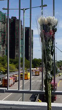 | Photo: AP/Ng Han Guan : A bouquet of flower is placed at an overhead bridge near the site of a fire at Wang Fuk Court, a residential estate in the Tai Po district of Hong Kong's New Territories.
