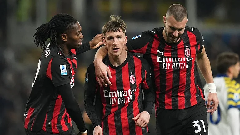 AC Milan's Alexis Saelemaekers, center, celebrates with Rafael Leao, left, and Strahinja Pavlovic after scoring his side's opening goal during the Serie A soccer match between Parma and Milan in Parma, Italy. - | Photo: Massimo Paolone/LaPresse via AP
