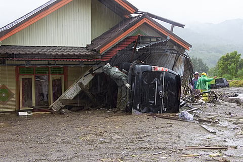 Rescuers search for victims at a village hit by flooding in Malalak, West Sumatra, Indonesia.