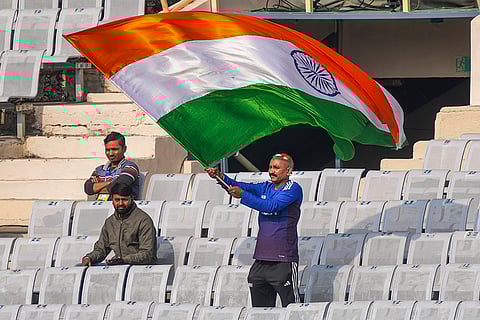 An Indian supporter waves the tricolour during the team's training session on the eve of the first ODI cricket match of a series between India and South Africa, in Ranchi, Jharkhand.