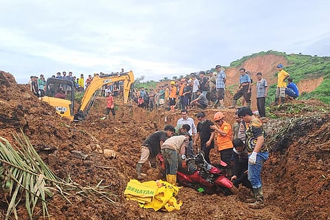 In this photo released by the Indonesian National Search and Rescue Agency (BASARNAS), rescuers remove a scooter buried in the mud as they search for victims at a village hit by a landslide in Batu Goading, North Sumatra, Indonesia. 