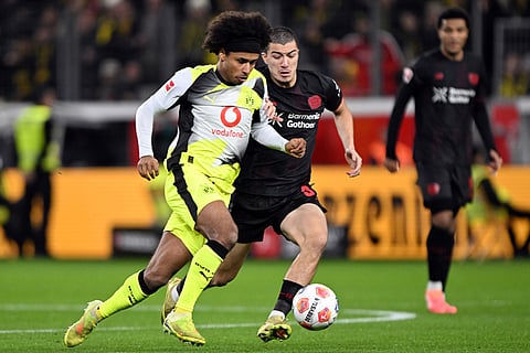 Bayer's Ibrahim Maza and Borussia's Karim Adeyemi, left, fight for the ball during the German Bundesliga soccer match between Bayer Leverkusen and Borussia Dortmund in Leverkusen, Germany.