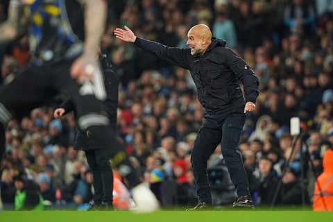 Manchester City's head coach Pep Guardiola gives instructions from the side line during the English Premier League soccer match between Manchester City and Leeds United in Manchester, England.