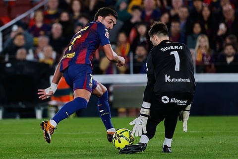 Barcelona's Ferran Torres, left, vies for the ball with Alaves' goalkeeper Antonio Sivera during a Spanish La Liga soccer match between Barcelona and Alaves, in Barcelona, Spain.