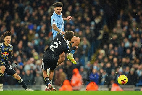 Manchester City's Nico O'Reilly, top, challenges for the ball with Leeds' Jayden Bogle during the English Premier League soccer match between Manchester City and Leeds United in Manchester, England.