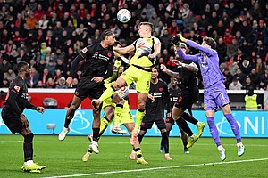| Photo: Federico Gambarini/dpa via AP : Bayer's Loïc Badé, center left, and Borussia's Nico Schlotterbeck fight for the ball during the German Bundesliga soccer match between Bayer Leverkusen and Borussia Dortmund in Leverkusen, Germany.