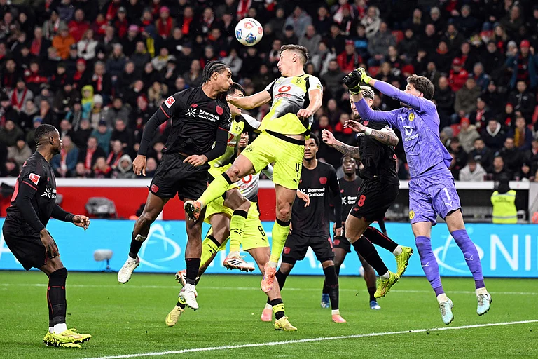 Bayer's Loïc Badé, center left, and Borussia's Nico Schlotterbeck fight for the ball during the German Bundesliga soccer match between Bayer Leverkusen and Borussia Dortmund in Leverkusen, Germany. - | Photo: Federico Gambarini/dpa via AP