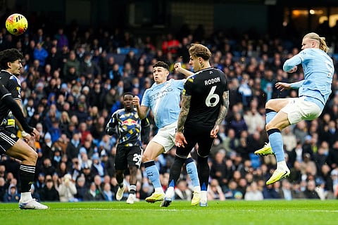 Manchester City's Phil Foden, center, scores during the English Premier League soccer match between Manchester City and Leeds United at Etihad Stadium, Manchester, England.