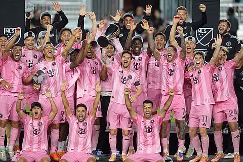 Inter Miami forward Lionel Messi (10) lifts the trophy as Inter Miami players celebrate winning an MLS Eastern Conference final soccer match against New York City FC in Fort Lauderdale, Florida. 