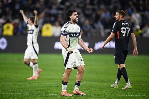 Vancouver Whitecaps forward Brian White, center, and Ryan Gauld, celebrate as San Diego FC defender Christopher McVey (97) walks away after a MLS Western Conference final soccer match in San Diego. 