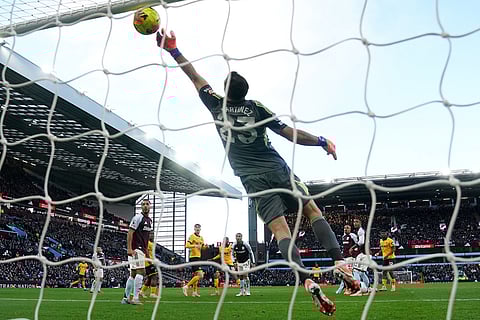 Aston Villa goalkeeper Emiliano Martinez saves a headed shot from Wolverhampton Wanderers' Yerson Mosquera, during the English Premier League soccer match between Aston Villa and Wolverhampton Wanderers, at Villa Park, in Birmingham, England.