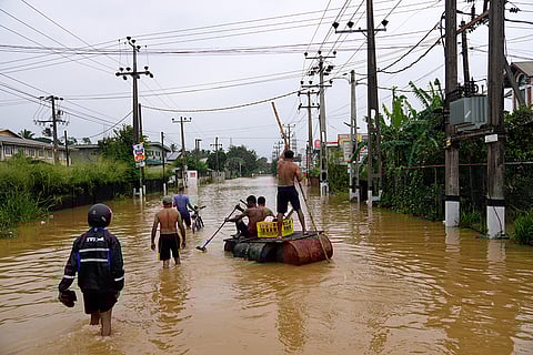 People use a crude raft to navigate a flooded street in Colombo, Sri Lanka.