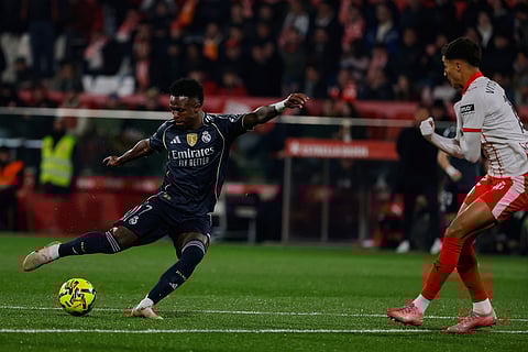 Real Madrid's Vinicius Junior, left, tries a shot during a Spanish La Liga soccer match between Girona and Real Madrid, in Girona, Spain.