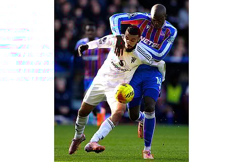 Manchester United's Noussair Mazraoui, left, and Crystal Palace's Jean-Philippe Mateta in action during the English Premier League soccer match between Crystal Palace and Manchester United in London.