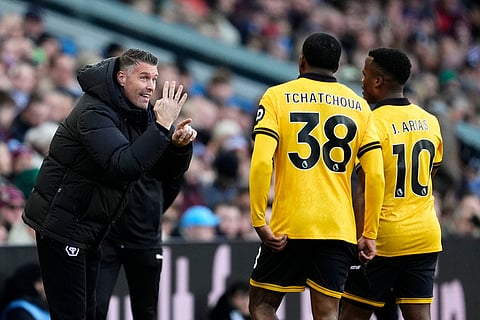 Wolverhampton Wanderers manager Rob Edwards, left, gives instructions to Jackson Tchatchoua, center and Jhon Arias, during the English Premier League soccer match between Aston Villa and Wolverhampton Wanderers, at Villa Park, in Birmingham, England.