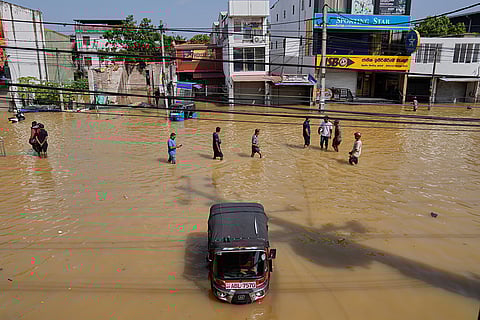 Flood victims wade through a submerged area of Colombo, Sri Lanka.
