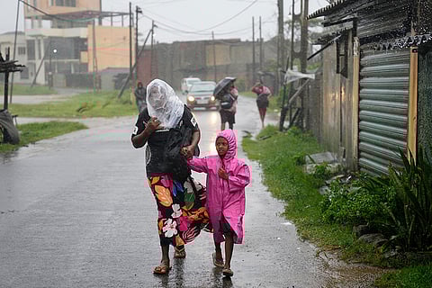 A woman and child walk under a downpour in Colombo, Sri Lanka.