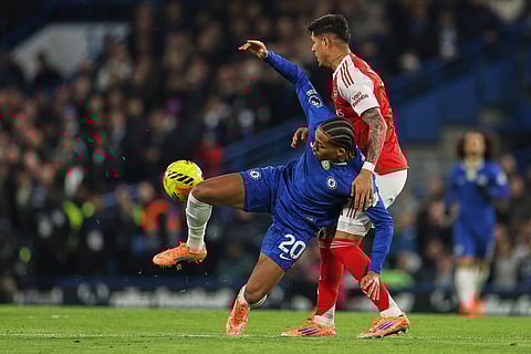 Arsenal's Piero Hincapie, right, challenges for the ball with Chelsea's Joao Pedro during the English Premier League soccer match between Chelsea and Arsenal in London, England.