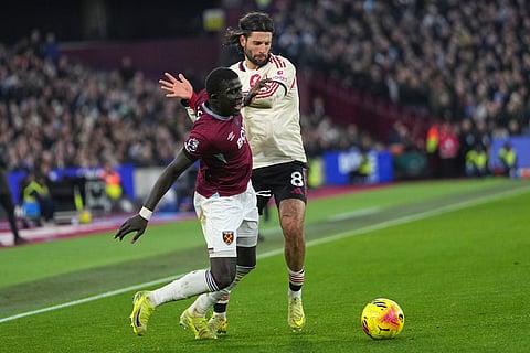 Liverpool's Dominik Szoboszlai, right, is challenged by West Ham's El Hadji Malick Diouf during the English Premier League soccer match between West Ham United and Liverpool, in London.
