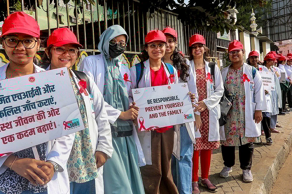 Students form a human chain during an awareness rally on World AIDS Day, in Bhopal. - | Photo: PTI