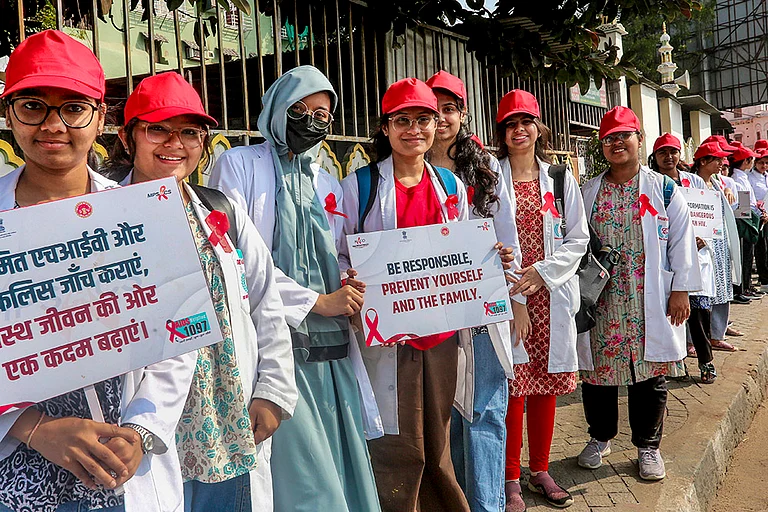 Students form a human chain during an awareness rally on World AIDS Day, in Bhopal. - | Photo: PTI