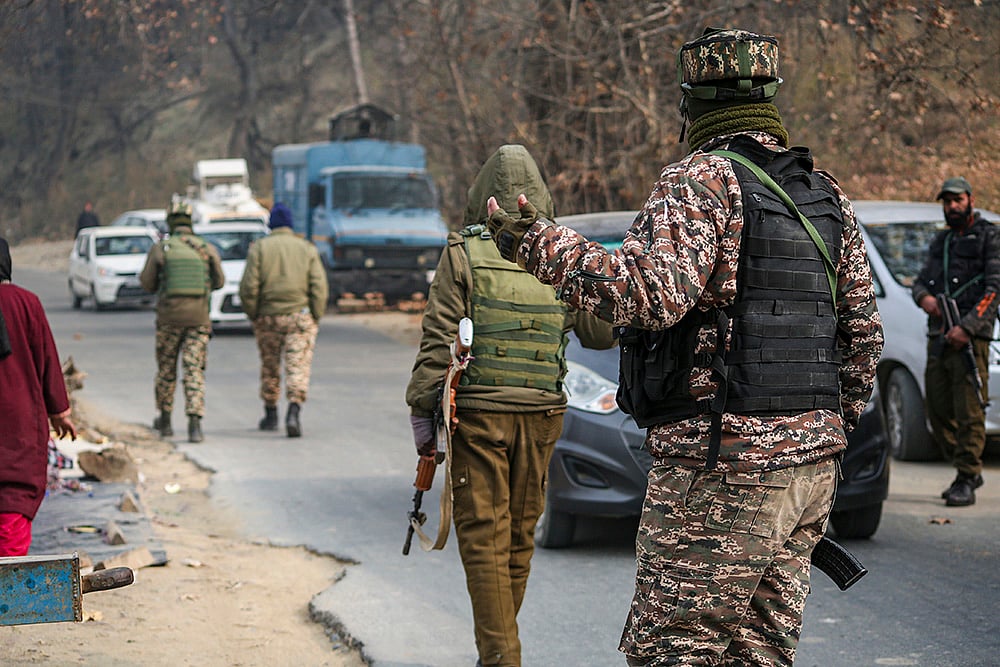 Security officials keep vigil during a raid, in Pulwama. The National Investigation Agency (NIA) carried out raids at eight locations in Pulwama, Shopian and Kulgam districts of Kashmir in connection with a "white-collar" terror module that was behind a car blast near Delhi's Red Fort.  - Photo: PTI