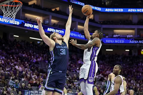Sacramento Kings guard Malik Monk, right, makes a shot over Memphis Grizzlies center Jock Landale (31) during the second half of an NBA basketball game in Sacramento, California. 