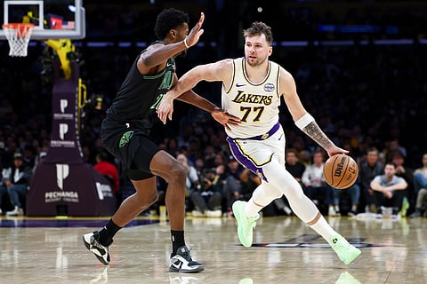 Los Angeles Lakers guard Luka Doncic (77) drives against New Orleans Pelicans center Yves Missi, left, during the second half of an NBA basketball game, in Los Angeles. 