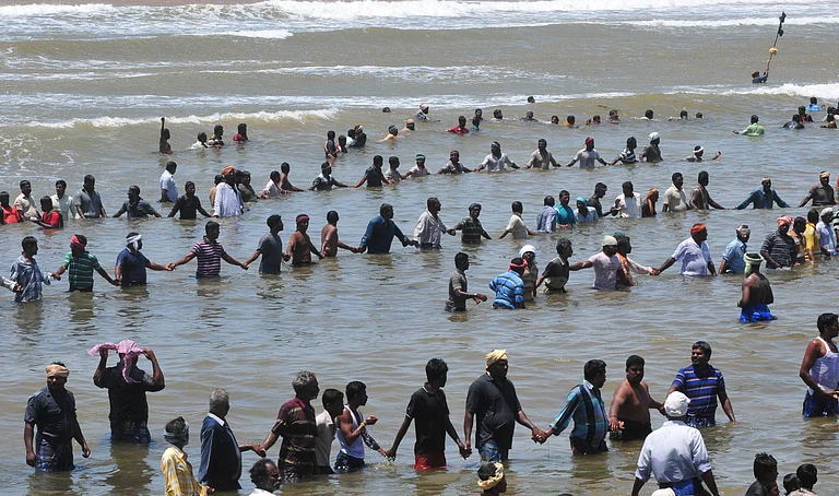 Activists and residents stand in the waters of the Bay of Bengal and shout slogans as they protest against the Russian-built Kudankulam Atomic Power Project, background, at Kudankulam, about 700 kilometers from Chennai, Tamil Nadu state on Sept. 13, 2012. Villagers in India s southern state of Tamil Nadu have renewed their protest against a newly built nuclear plant on Monday, demanding to halt the loading of nuclear fuel in the reactors, which is likely to get done over the next few days, according to local TV channel TIMES NOW. - IMAGO / Xinhua