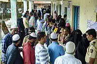 Photo: PTI : People wait in a queue to cast their votes at a polling booth during the Maharashtra local body elections, at Taloja, in Navi Mumbai.