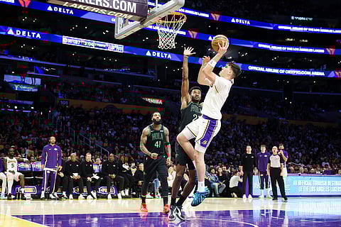Los Angeles Lakers forward Jake LaRavia, right, drives against New Orleans Pelicans center Yves Missi, center, as New Orleans Pelicans guard Saddiq Bey (41) watches during the second half of an NBA basketball game in Los Angeles. 