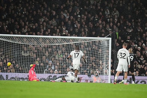 Manchester City's Erling Haaland, right, scores the opening goal during the English Premier League soccer match between Fulham and Manchester City in London.