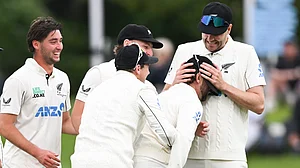 (Andrew Cornaga/Photosport via AP) : New Zealand's Jacob Duffy, right, congratulates teammate Devon Conway on his catch to dismiss the West Indies Tagenarine Chanderpaul during the second day of their cricket test match in Christchurch, New Zealand, Wednesday, Dec. 3, 2025