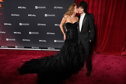 Singer Miley Cyrus kisses her boyfriend Maxx Morando on the red carpet at the premiere of the film "Avatar: Fire and Ash" at Dolby Theatre in Los Angeles. 