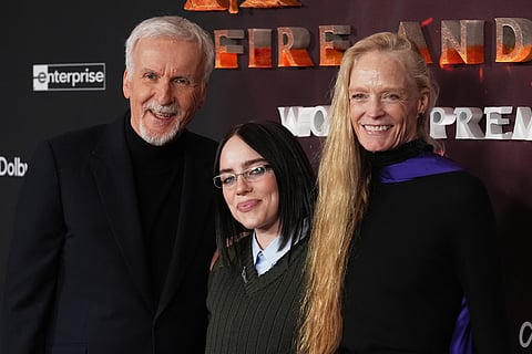 James Cameron, left, director and co-writer of "Avatar: Fire and Ash," poses with his wife Suzy Amis Cameron, right, and guest Billie Eilish at the premiere of the film at Dolby Theatre in Los Angeles. 