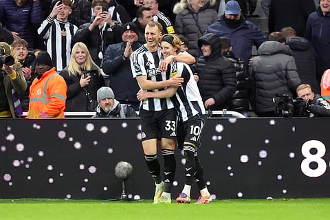 Newcastle United's Anthony Gordon, right, celebrates scoring their side's second goal of the game during the Premier League soccer match between Newcastle United and Tottenham Hotspur in Newcastle, England.