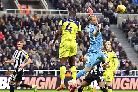 Newcastle United goalkeeper Aaron Ramsdale saves a shot from Tottenham Hotspur's Kevin Danso during their English Premier League soccer match in Newcastle, England.