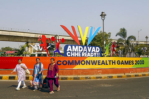 Commuters walk past newly-setup standees after the city was formally awarded hosting rights of the ‘Commonwealth Games 2030’, in Ahmedabad.