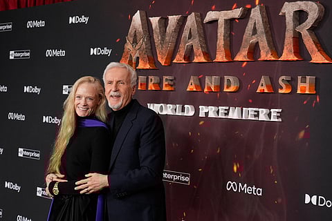 James Cameron, right, director and co-writer of "Avatar: Fire and Ash," poses with his wife Suzy Amis Cameron at the premiere of the film at Dolby Theatre in Los Angeles. 